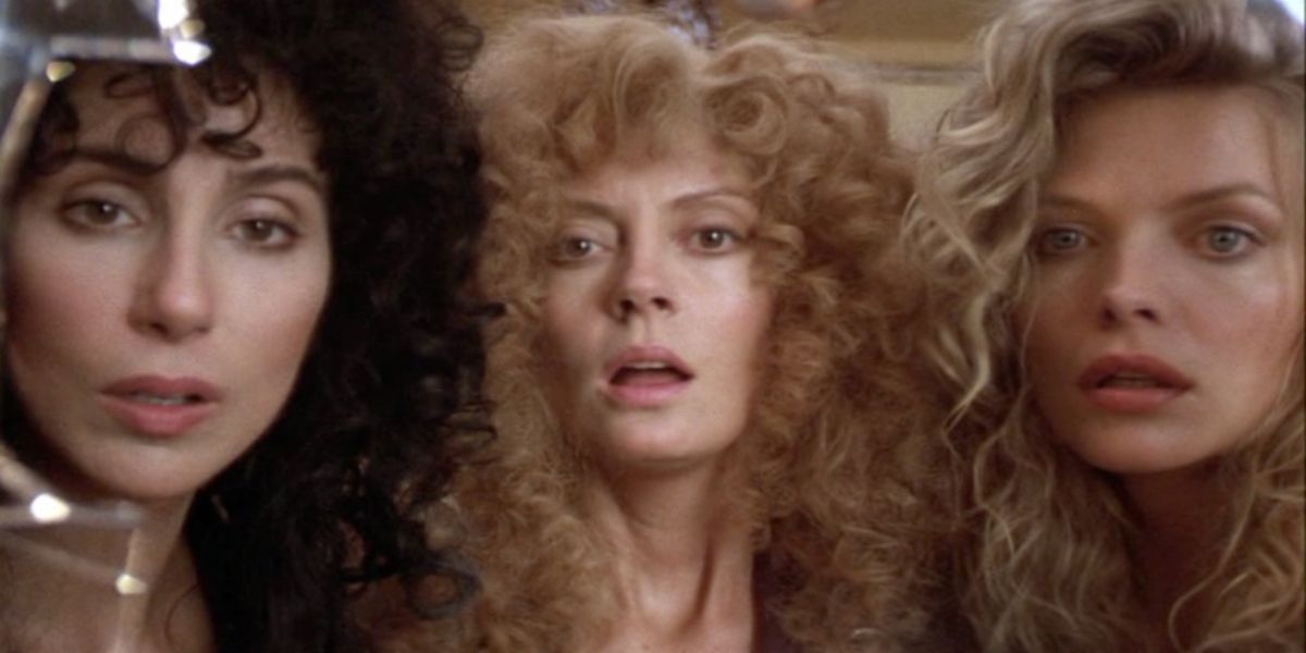 Cher, Susan Sarandon, and Michelle Pfeiffer looking shocked in The Witches of Eastwick.
