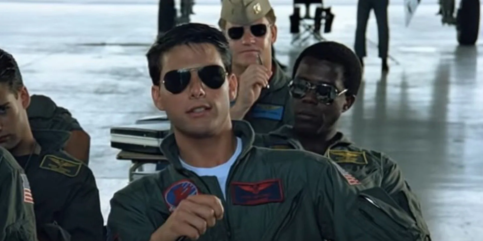 Tom Cruise as Maverick wearing aviator sunglasses during class in Top Gun