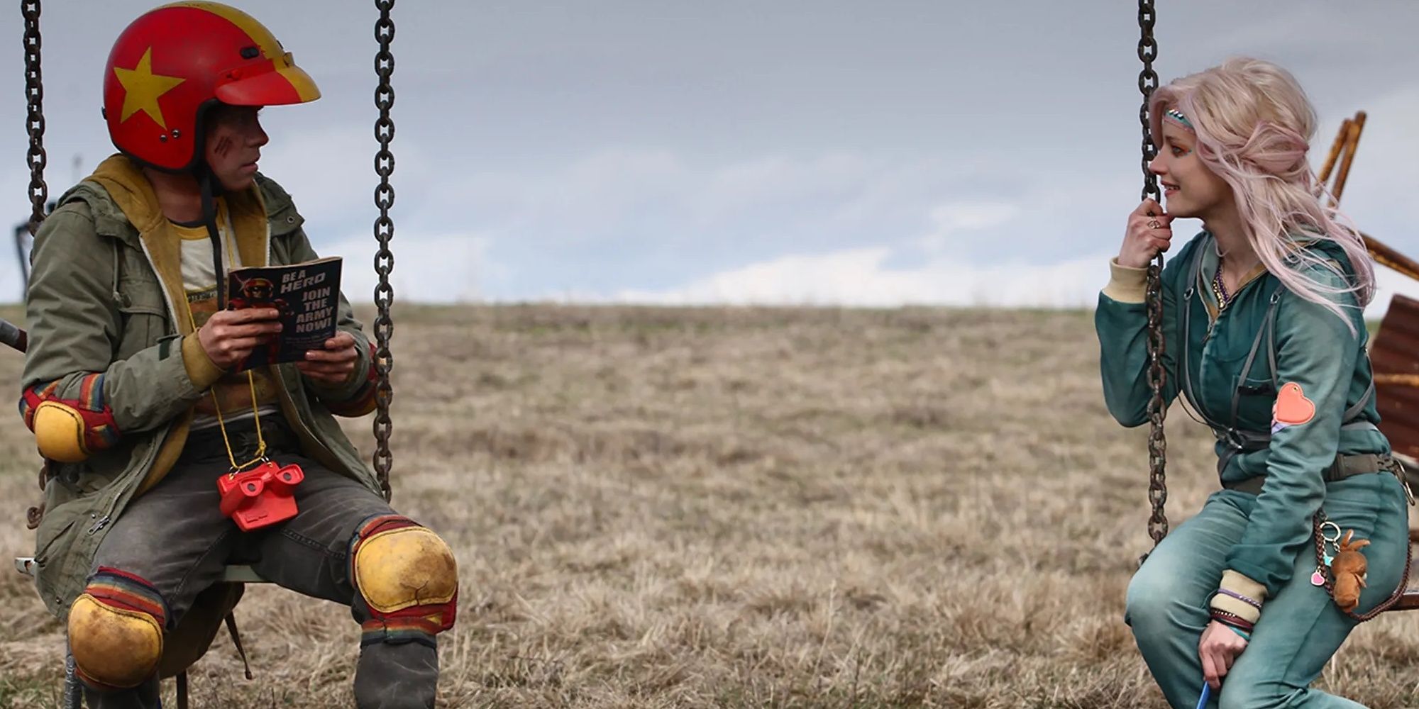 The Kid and Apple sit on a swing set in Turbo Kid