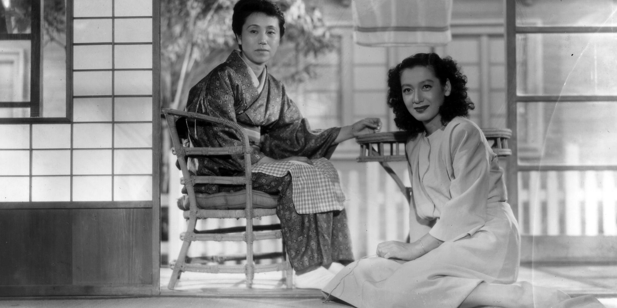 Two women sitting, one on a chair and one on the floor