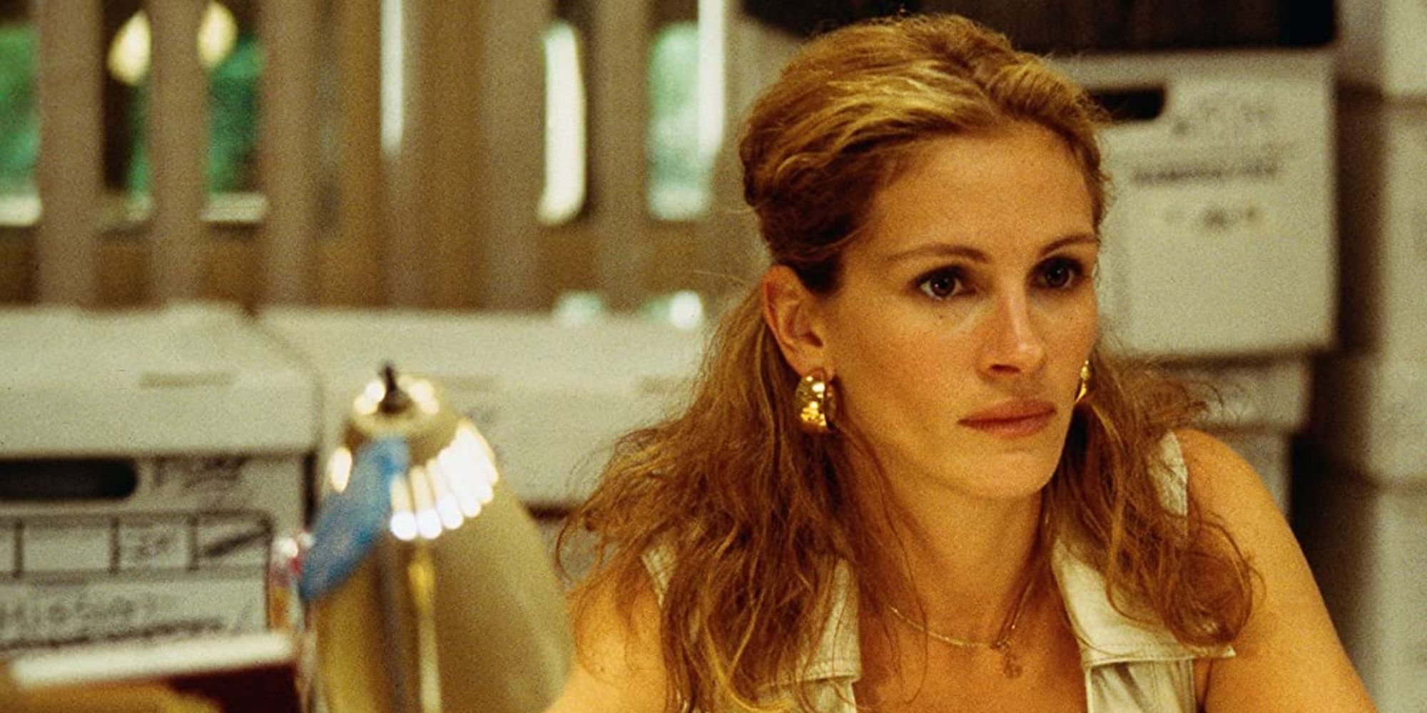 Un primer plano de Julia Roberts, quien interpreta a Erin Brockovich, sentada en su escritorio en Erin Brockovich.