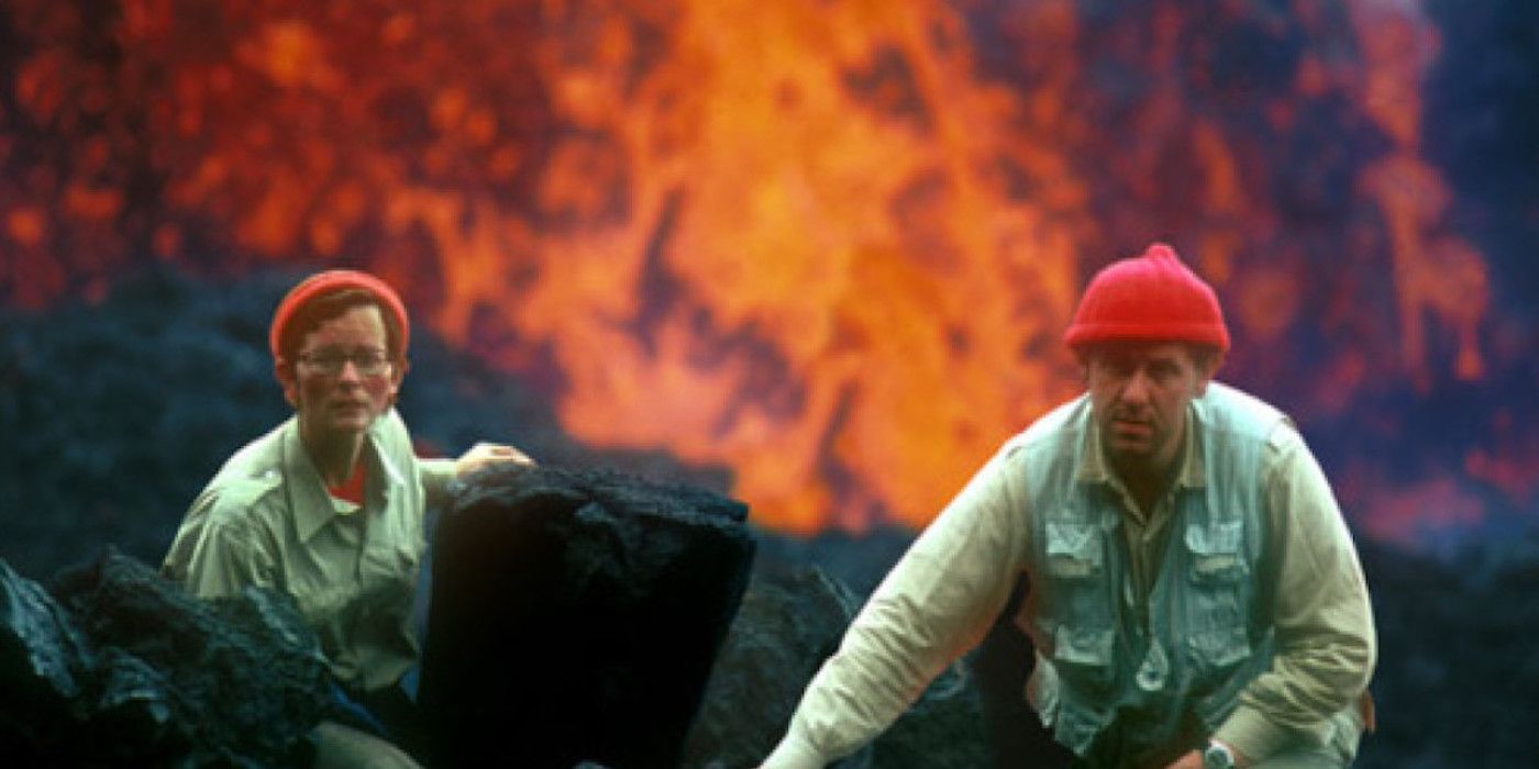 Fire of Love power couple Maurice and Katia Krafft sit side by side before a caldera spewing lava. 