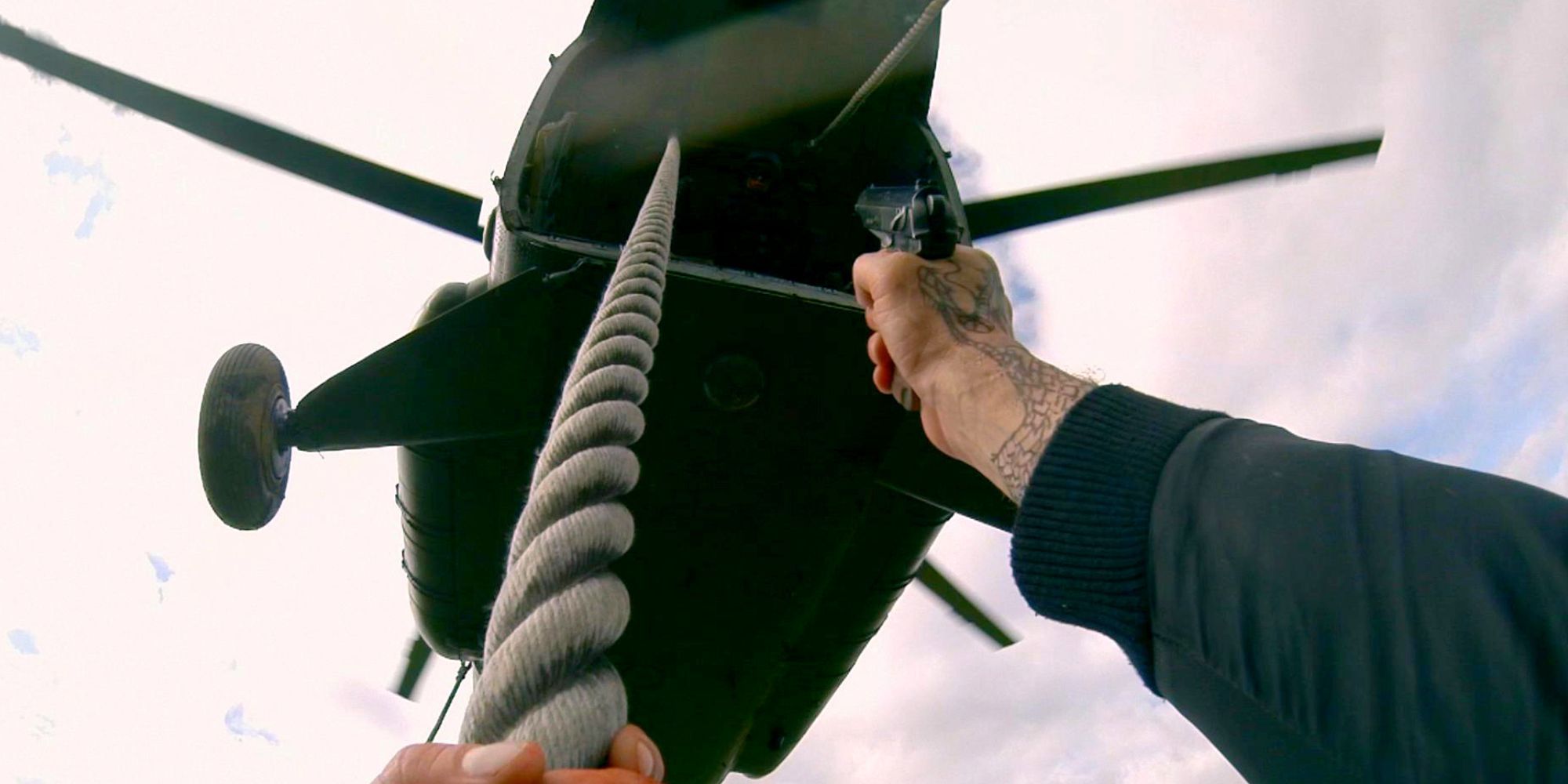 Henry slides down a rope from a helicopter while shooting at the enemies above him