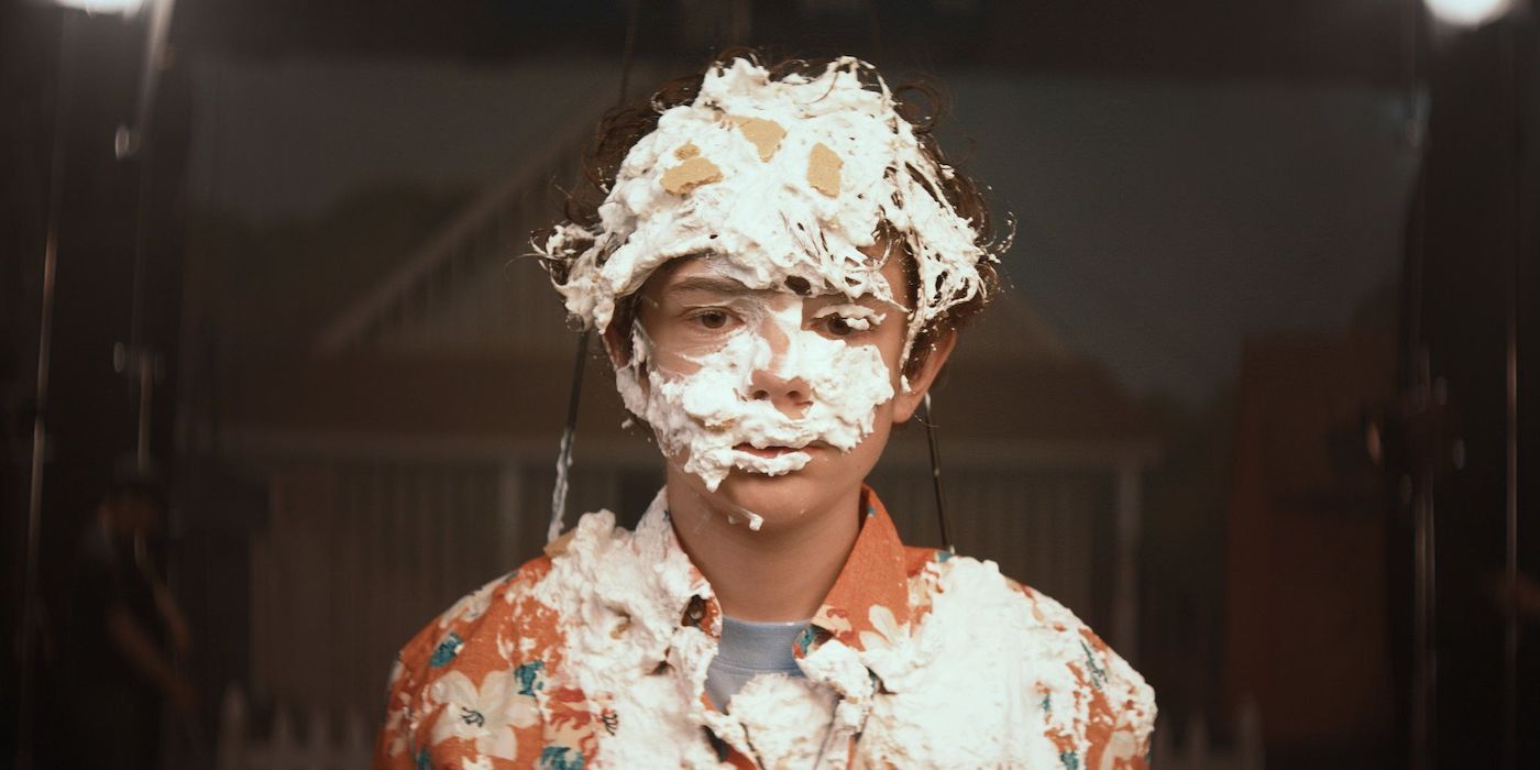 Noah Jupe in Honey Boy with his face covered in cake. 