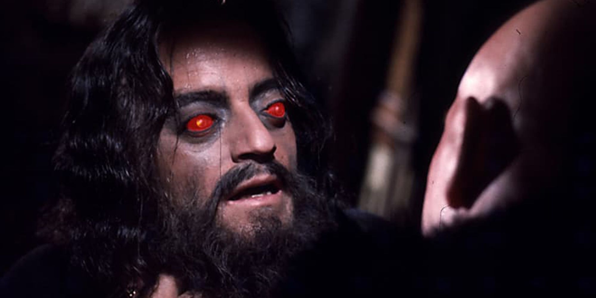 A man with red eyes choking another man in Horror Express