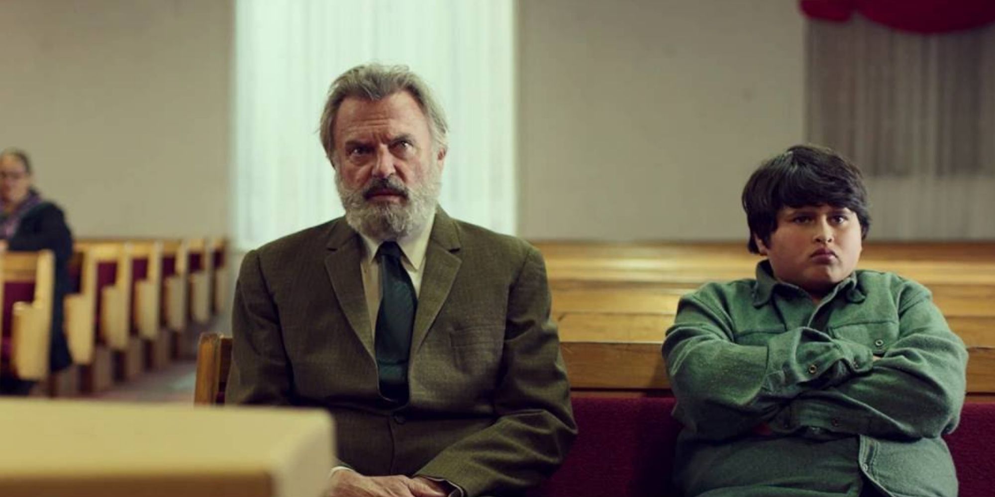 Hec (Sam Neill) and Ricky Baker (Julian Dennison) sitting in church in 'Hunter for the Wilderpeople' (2016)