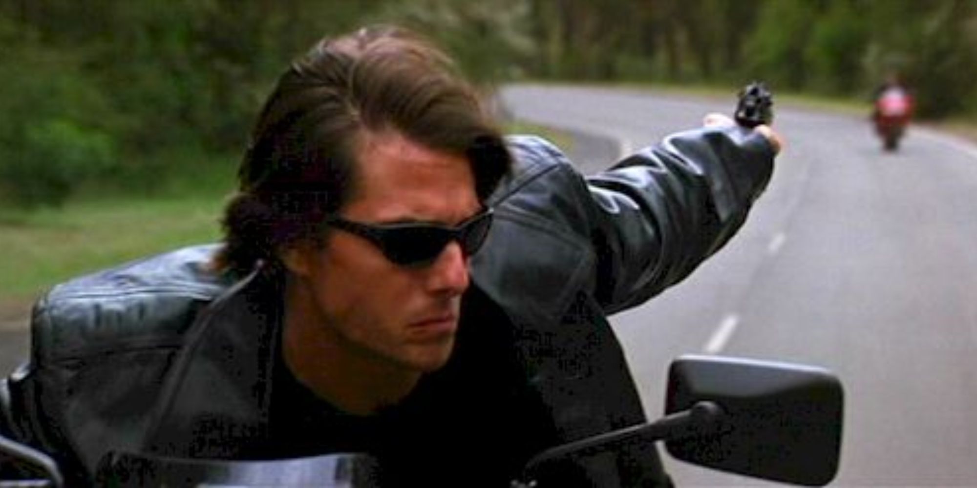 Ethan Hunt shoots at his pursuer during a motorcycle chase