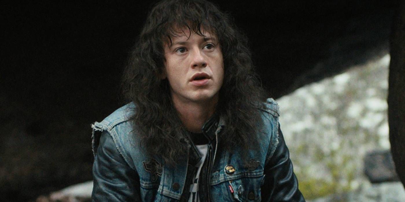 Joseph Quinn as Eddie Munson with long, wavy hair and a denim jacket in Stranger Things Season 4.