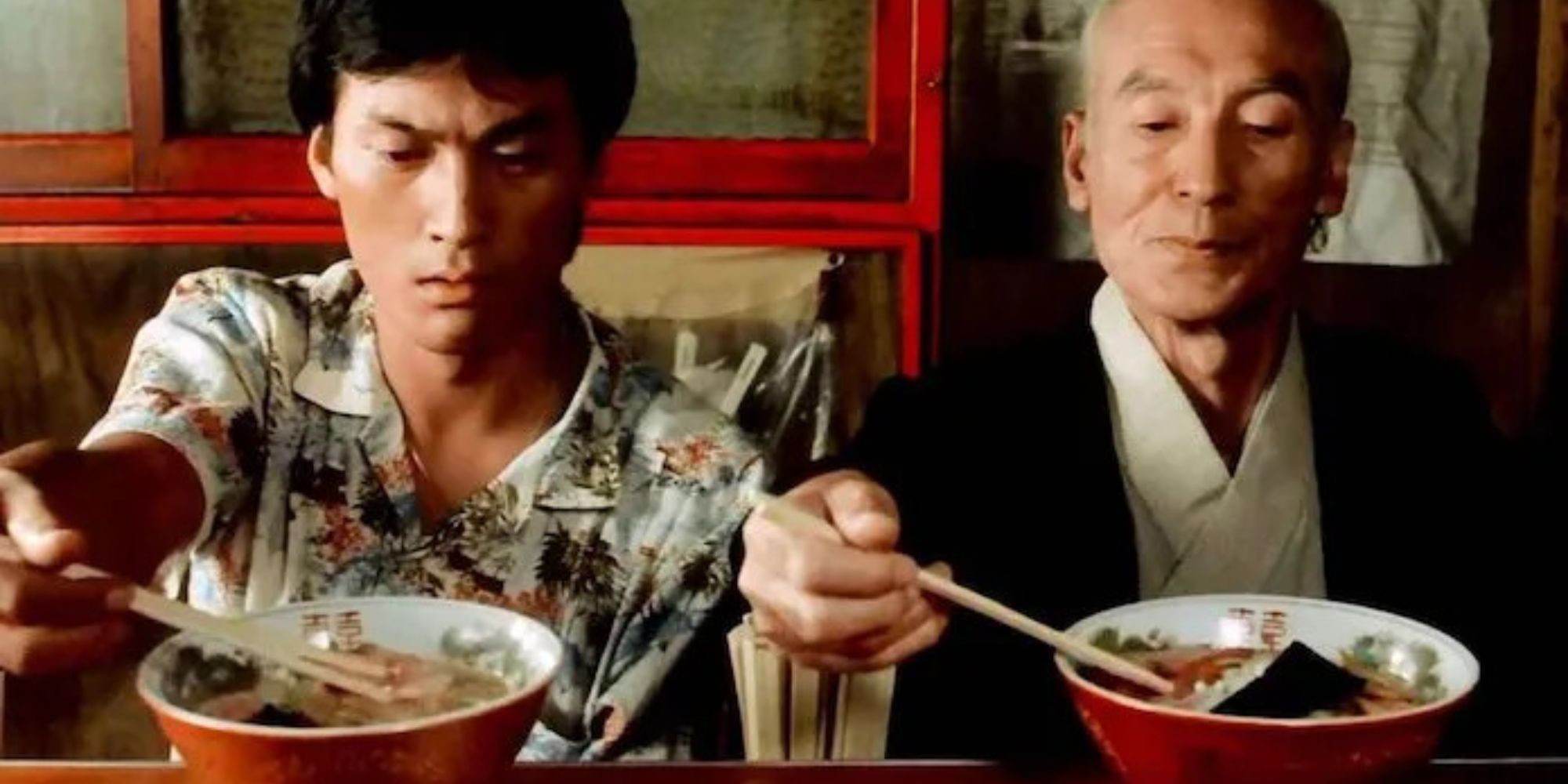 two men are eating ramen