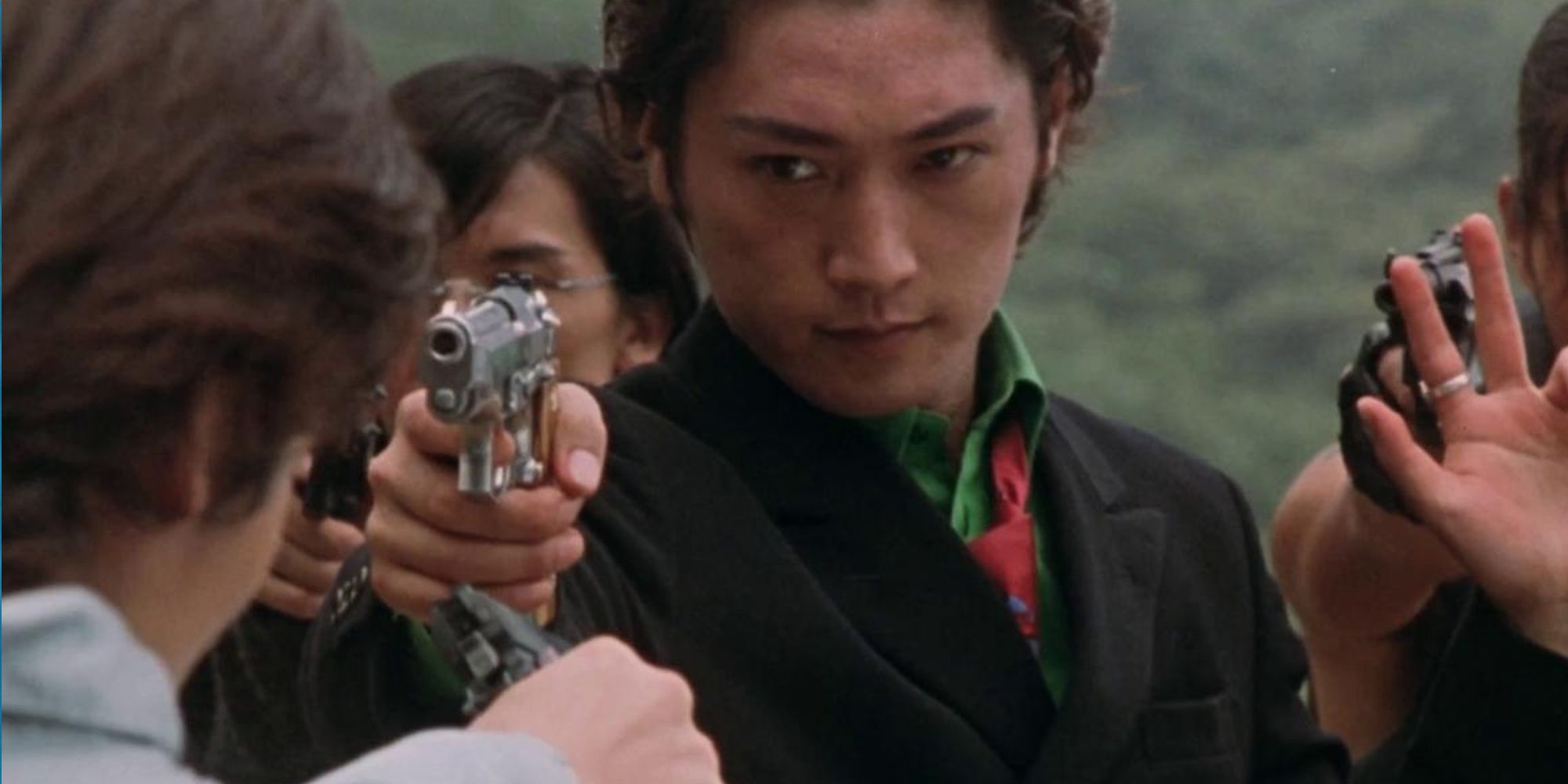 Kenji Matsuda pointing a gun at another man in Versus