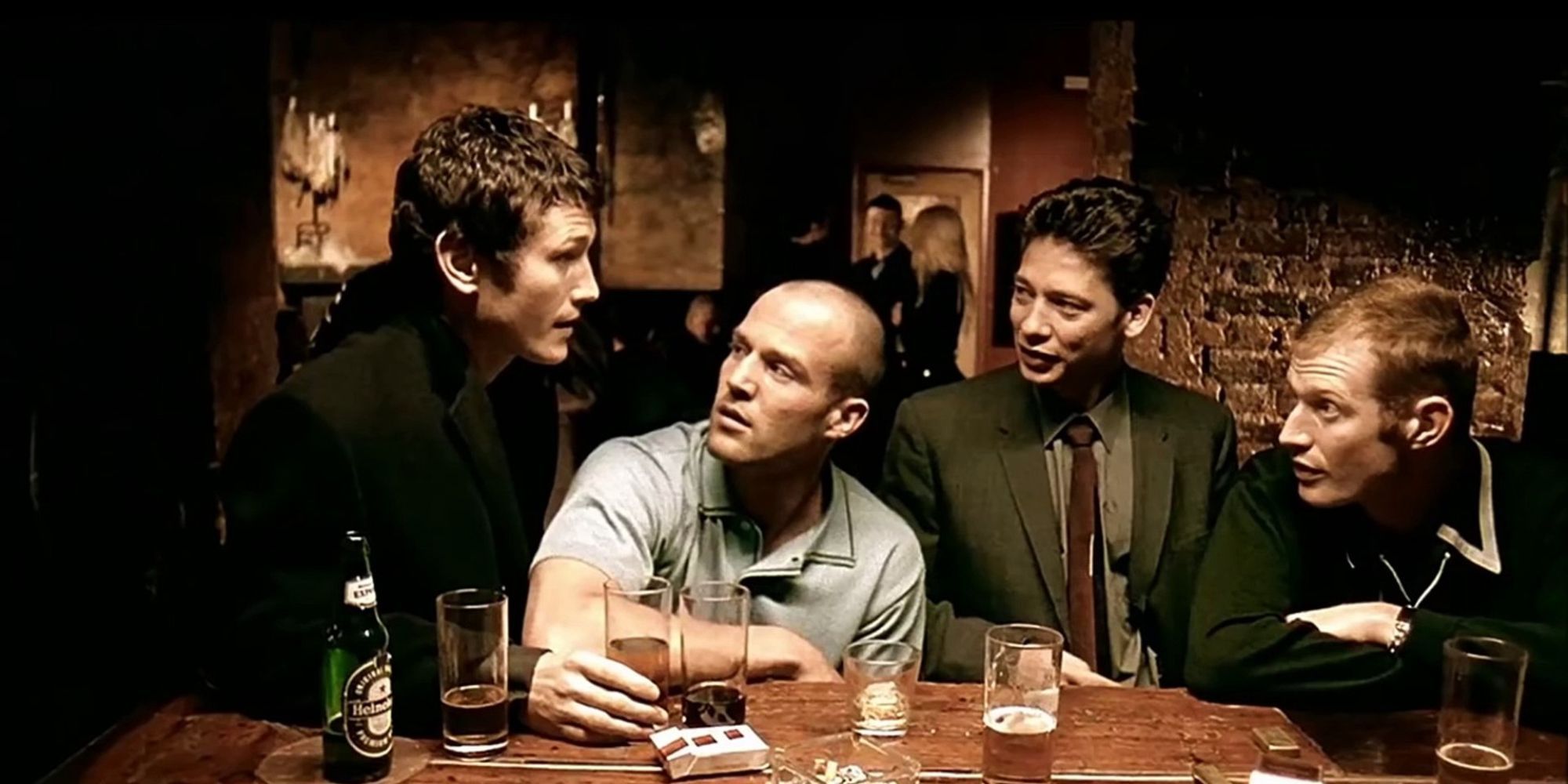 4 men sitting at a bar talking to each other
