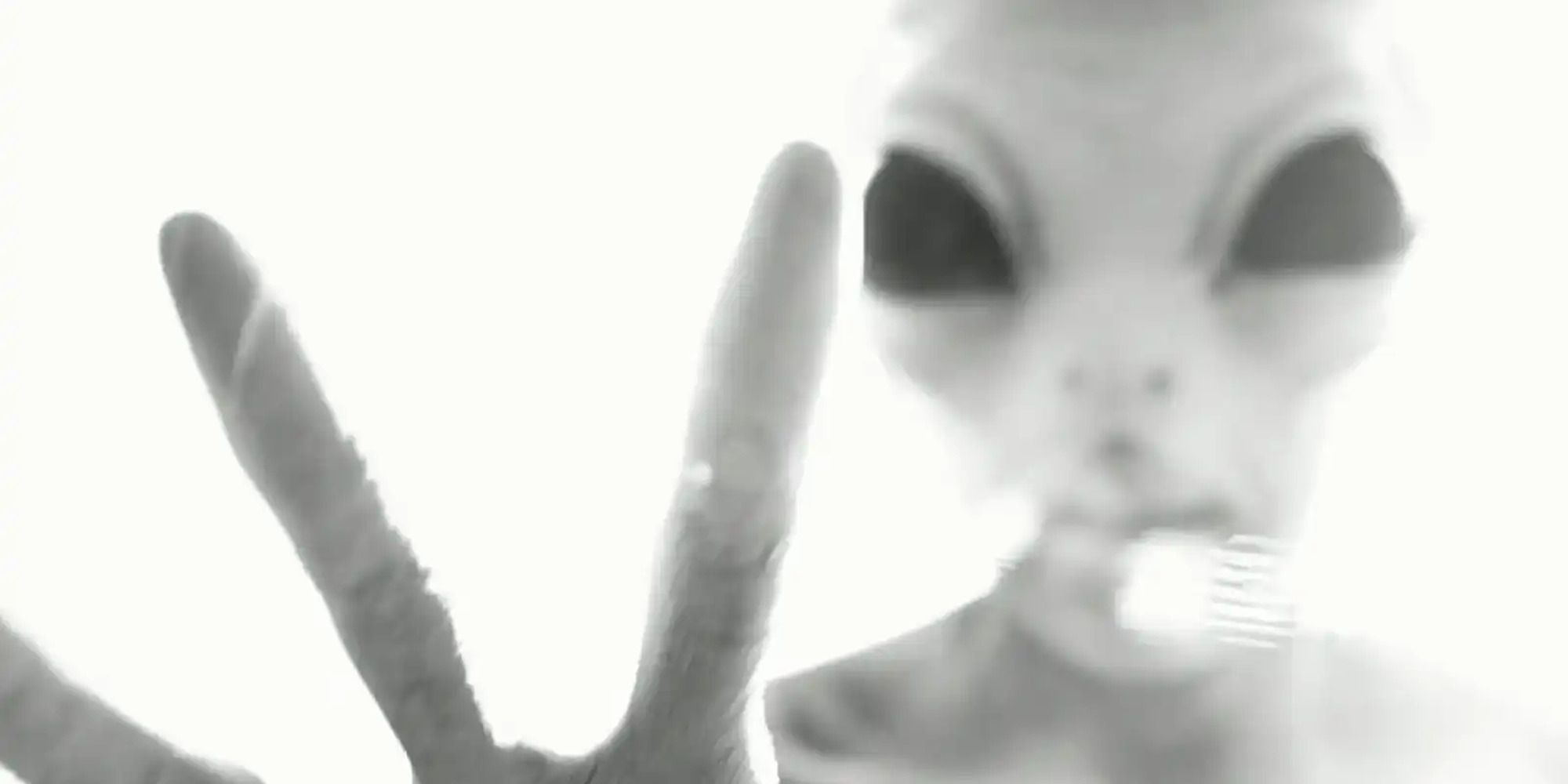 in black and white, an alien trying to grab the camera