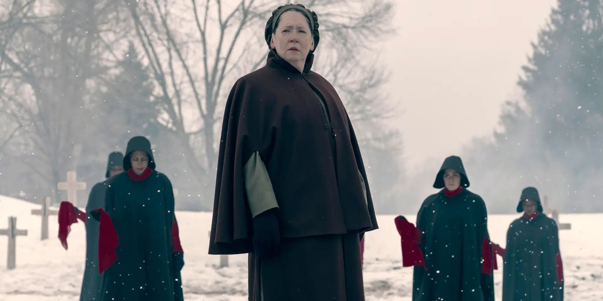 Aunt Lydia in the snow, with handmaids dressed in black in The Handmaid&rsquo;s Tale.