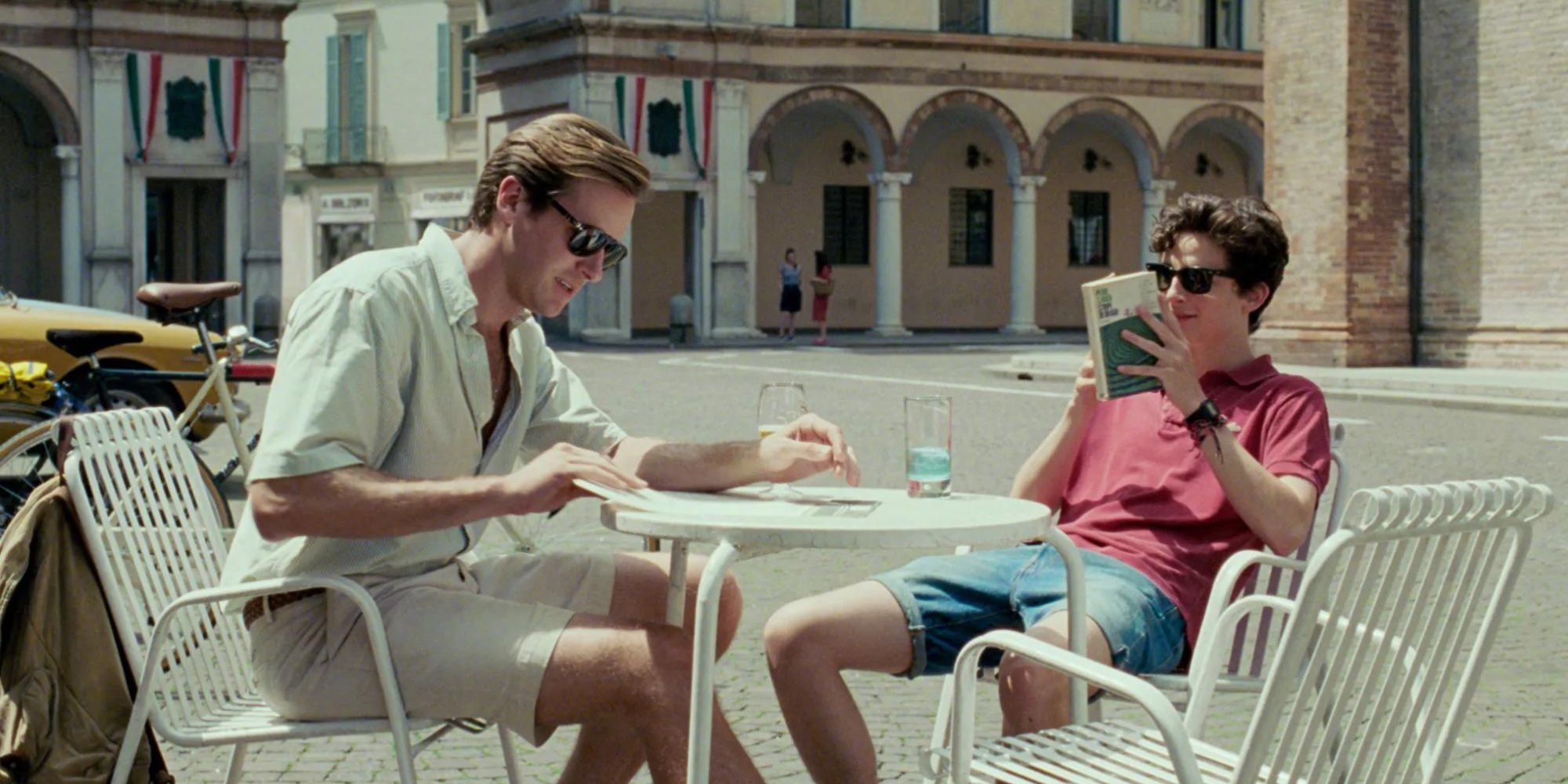 Oliver and Elio, played by Timothee Chalamet and Armie Hammer, are sitting outside in Call Me by Your Name