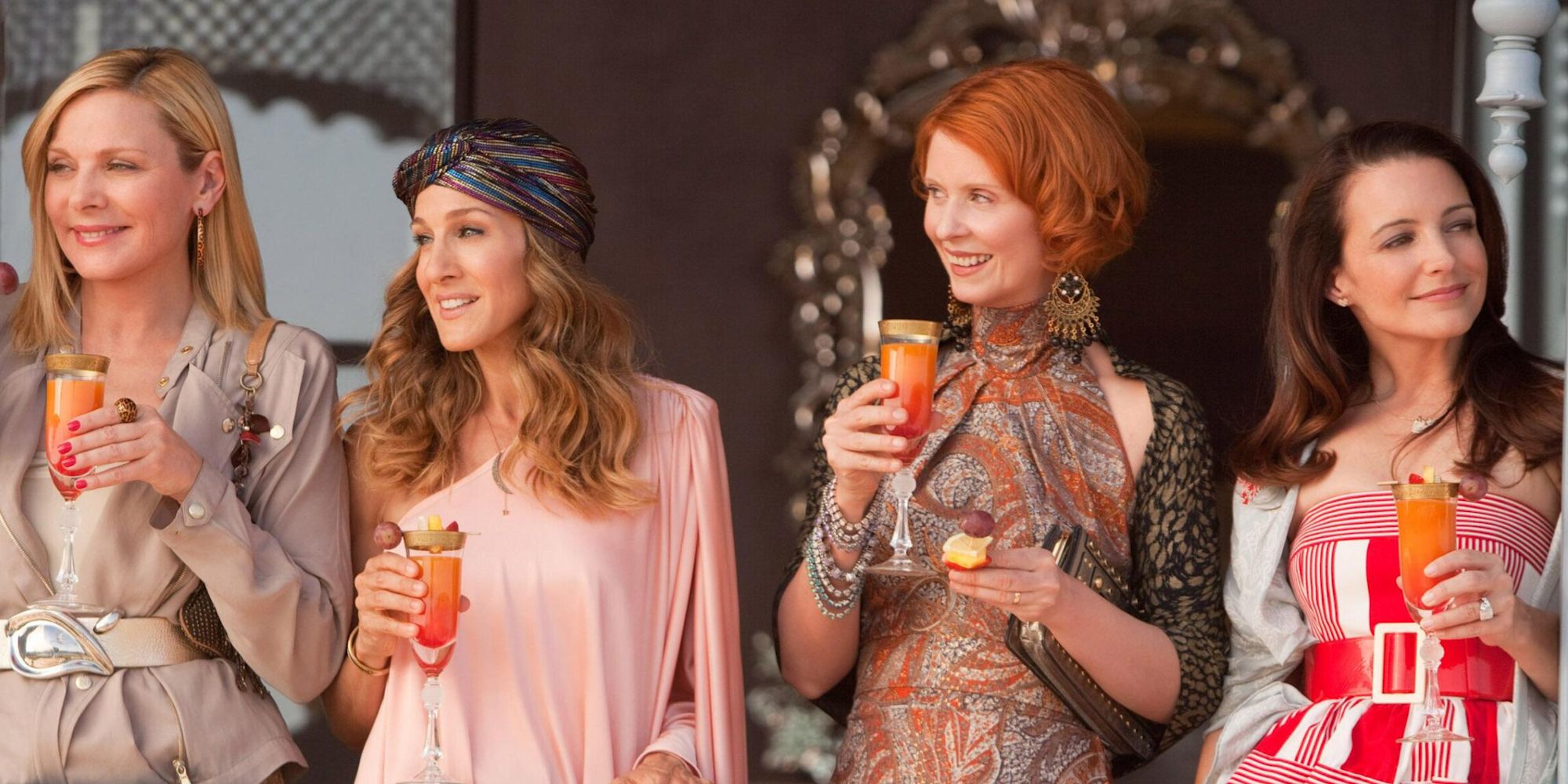 The cast of Sex and the City 2 holding champagne glasses and smiling.