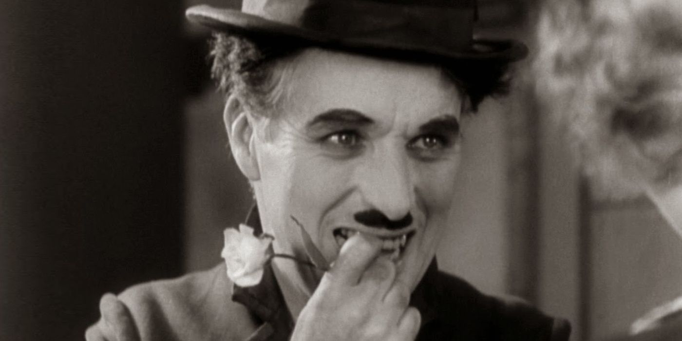 Charlie Chaplin as The Tramp smiling while biting his nail in City Lights.