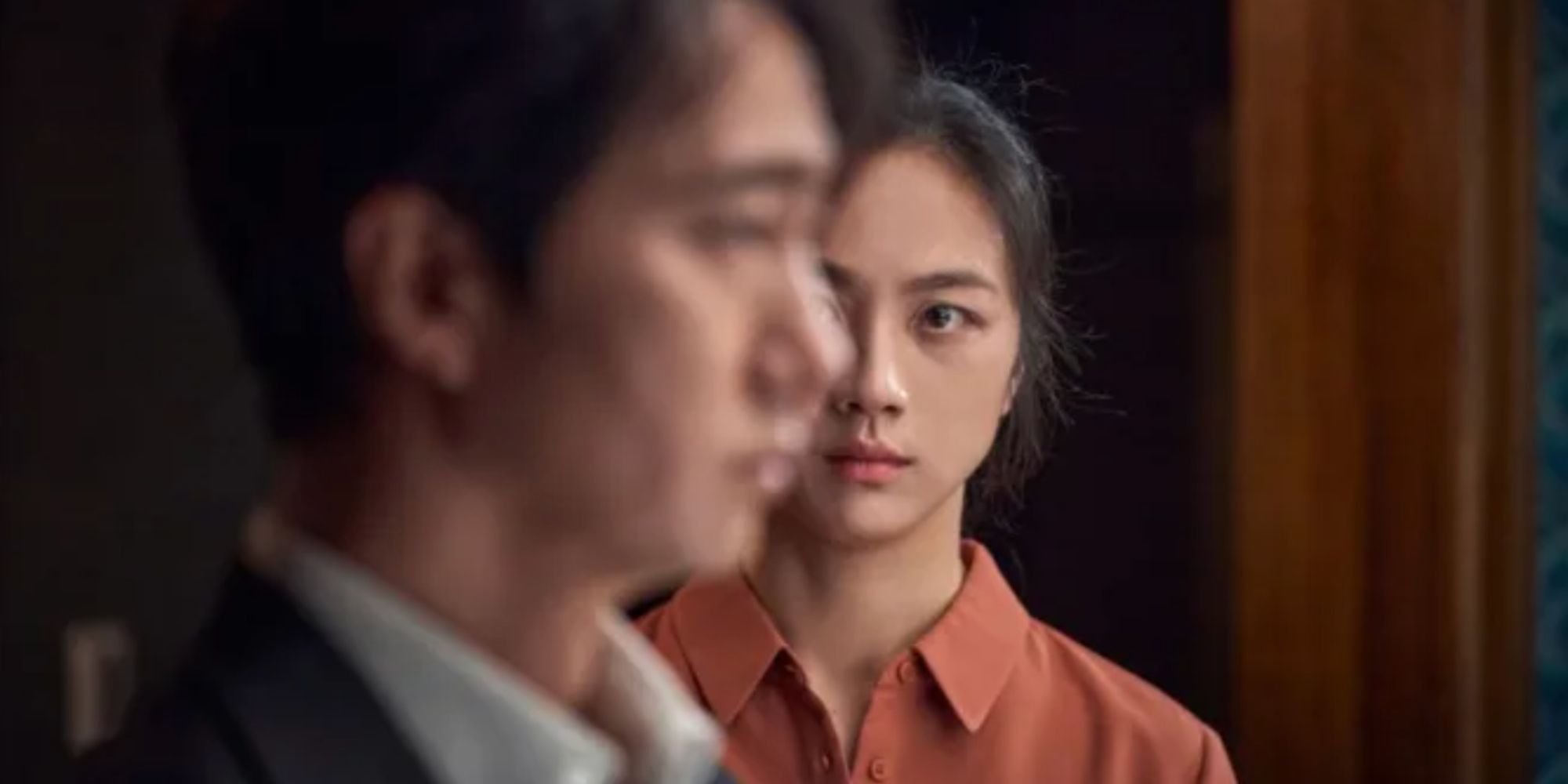 Park Hae-il and Tang Wei looking at each other in Decision to Leave