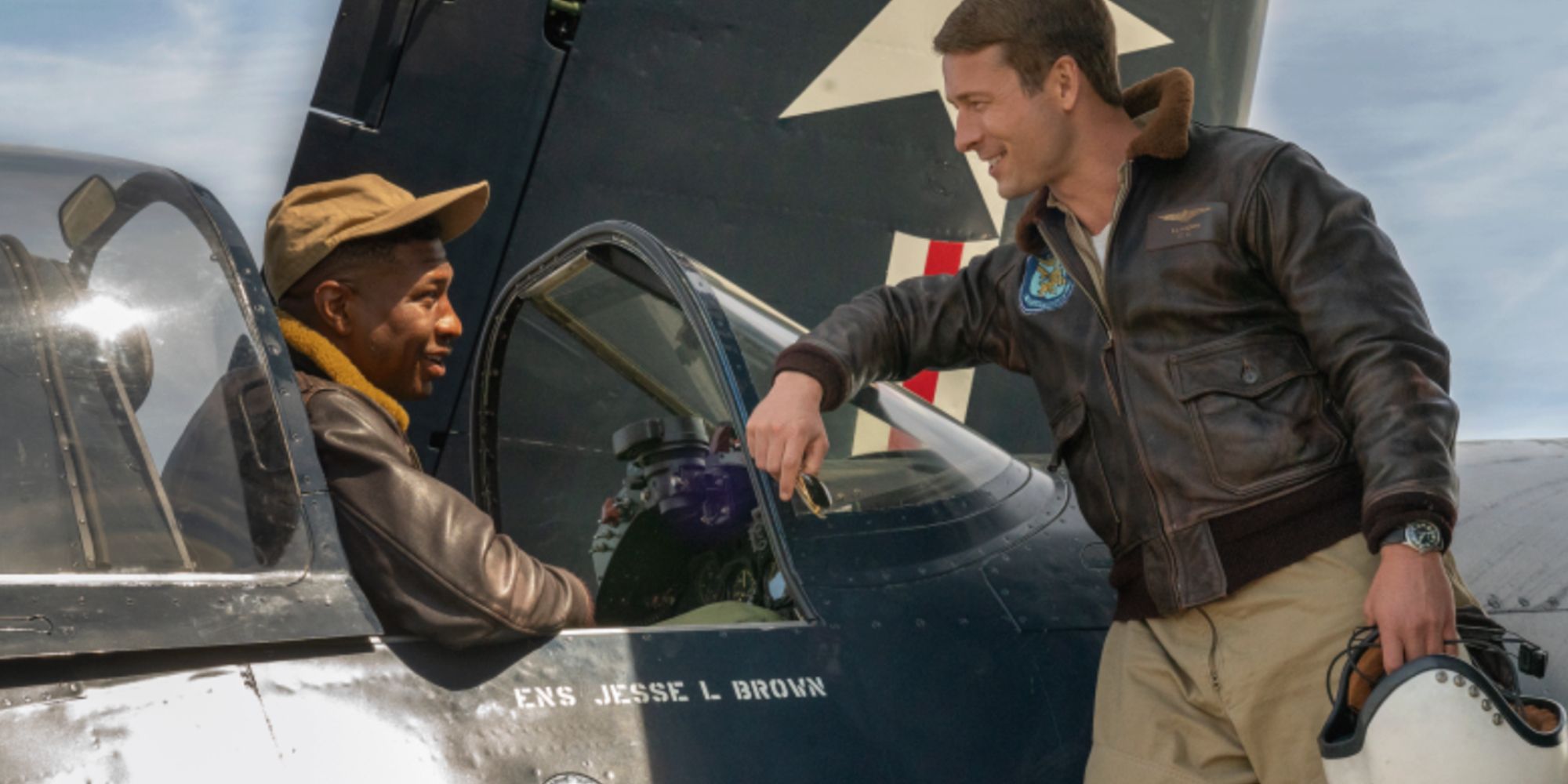 Jonathan Majors in a plane with Glen Powell looking at him