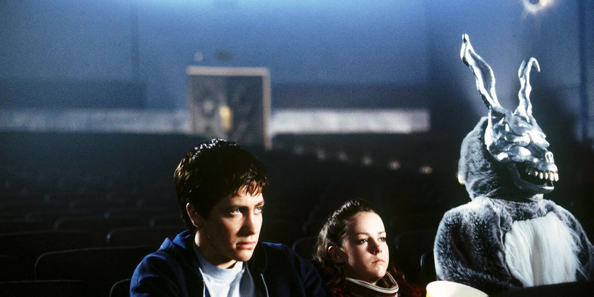 Donnie, Gretchen, and Frank the Rabbit in a movie theater in Donnie Darko.