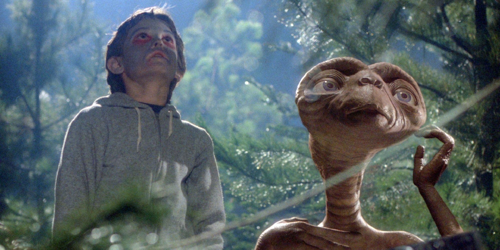 ET e Elliot estão observando o céu na floresta em 'ET the Extra-terrestrial'.