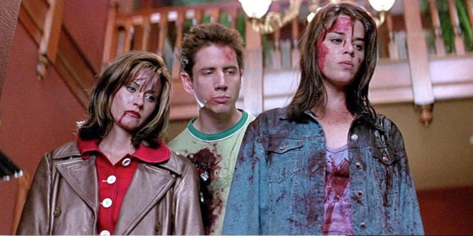 Gale, Randy, and Sidney covered in blood looking down at something off-camera in Scream.