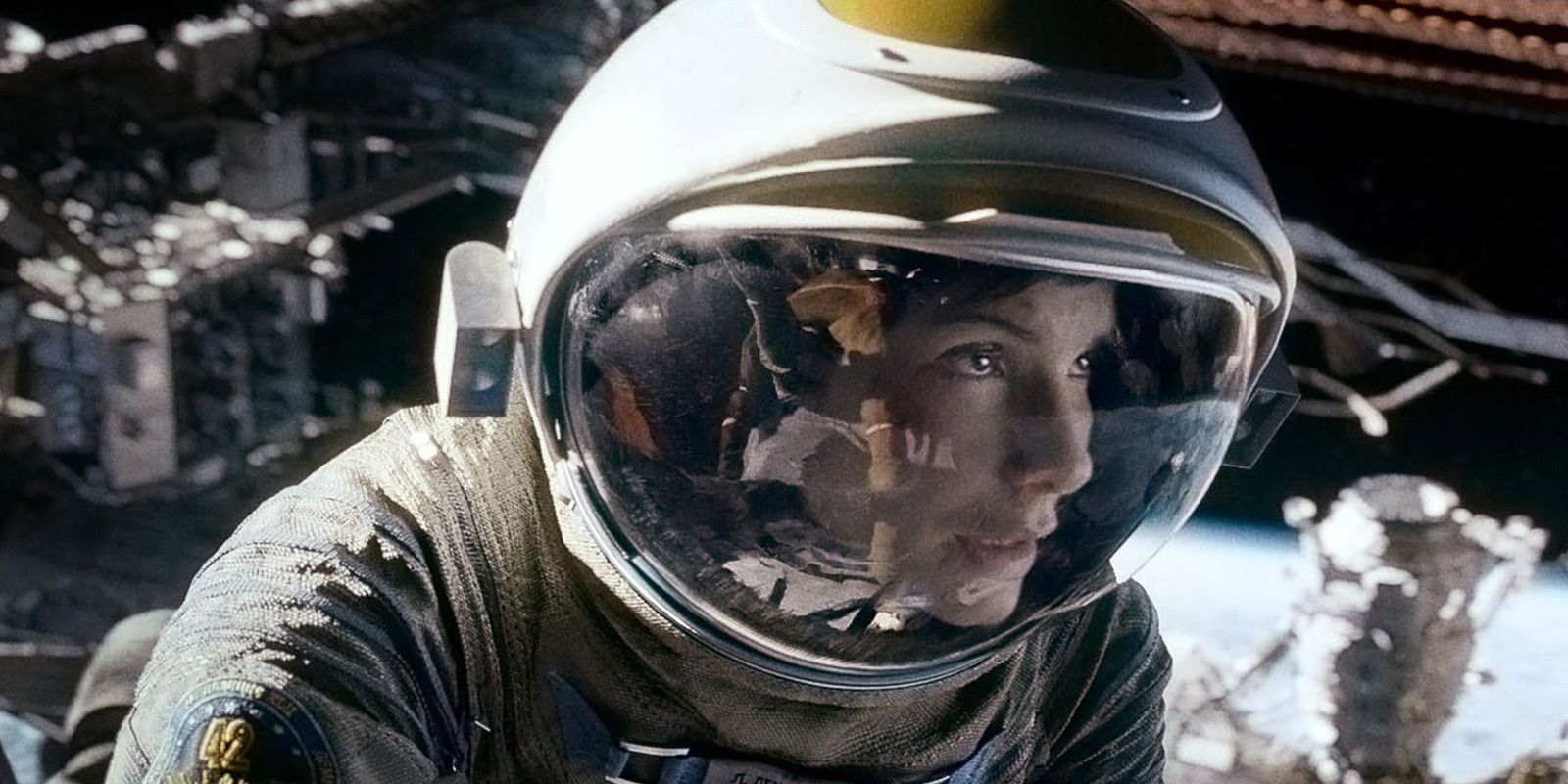 Sandra Bullock as Ryan Stone in her space-suit looking at an object offscreen in Gravity