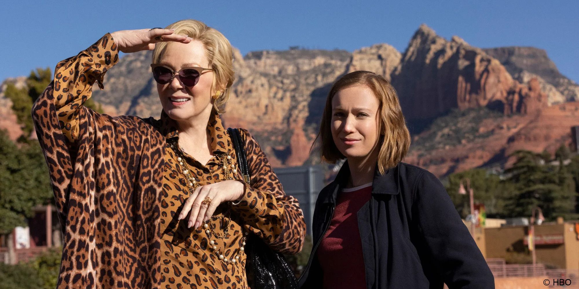Jean Smart as Deborah Vance and Hannah Einbinder in Ava stand side by side in the desert looking off screen in Hacks