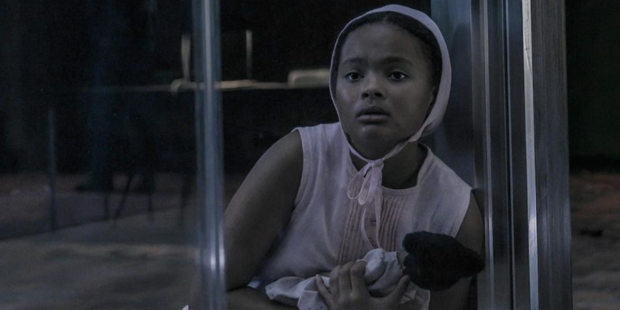 Hannah clutching onto a doll, scared