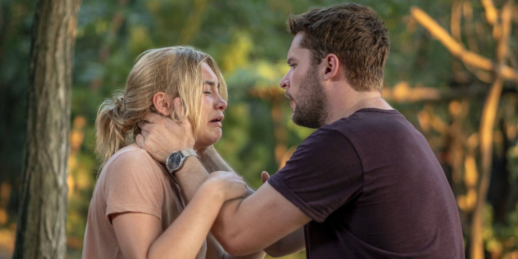 Christian (Jack Reynor) holds Dani's (Florence Pugh) face as she sobs in the woods in Midsommar