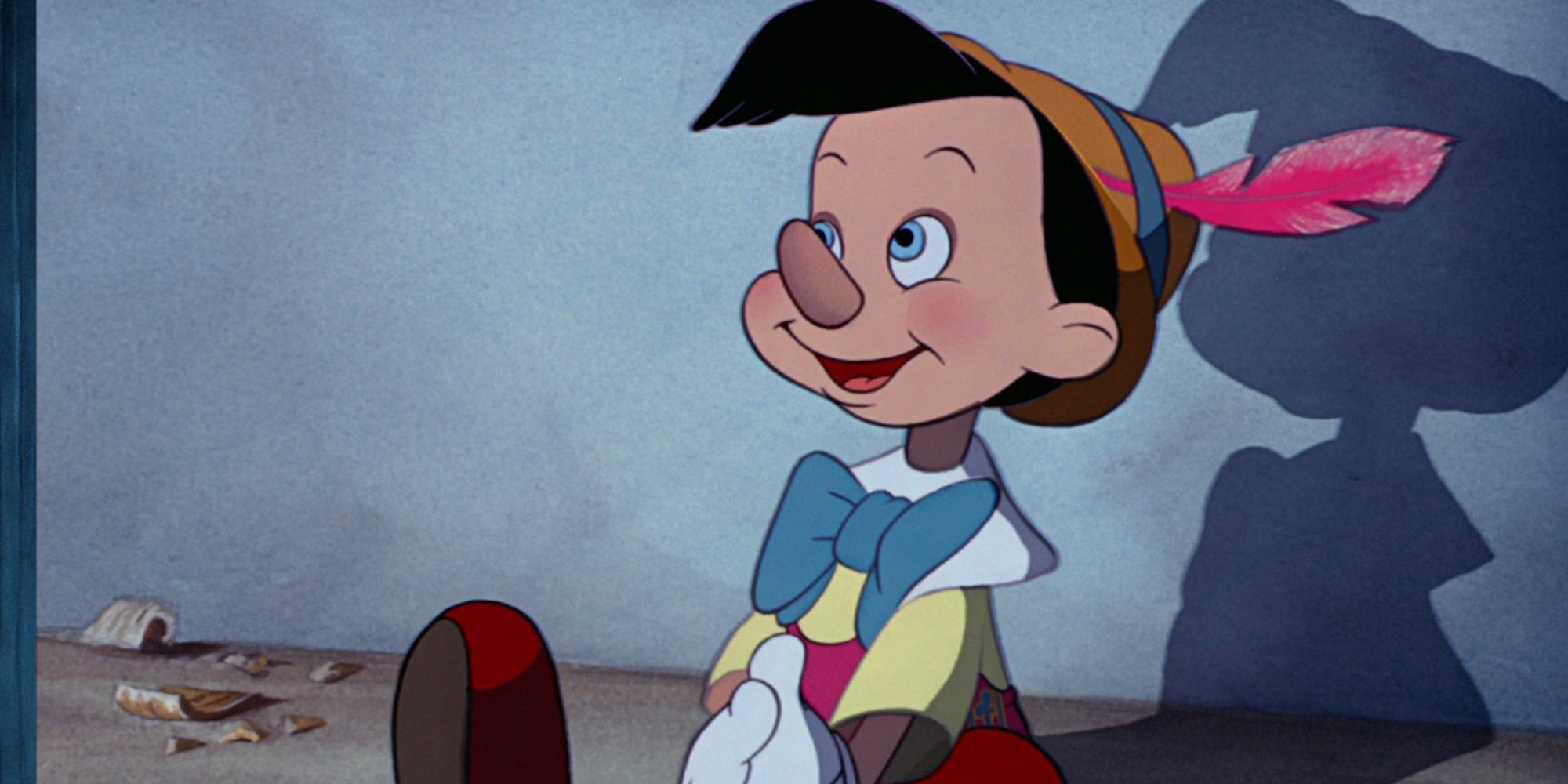 Pinocchio smiling while sitting down in Disney's Pinocchio.