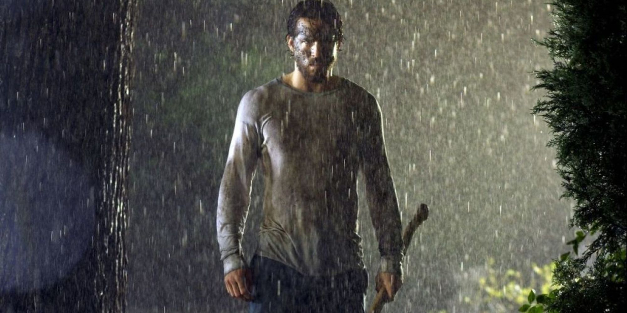 Ryan Reynolds holding an axe in the rain