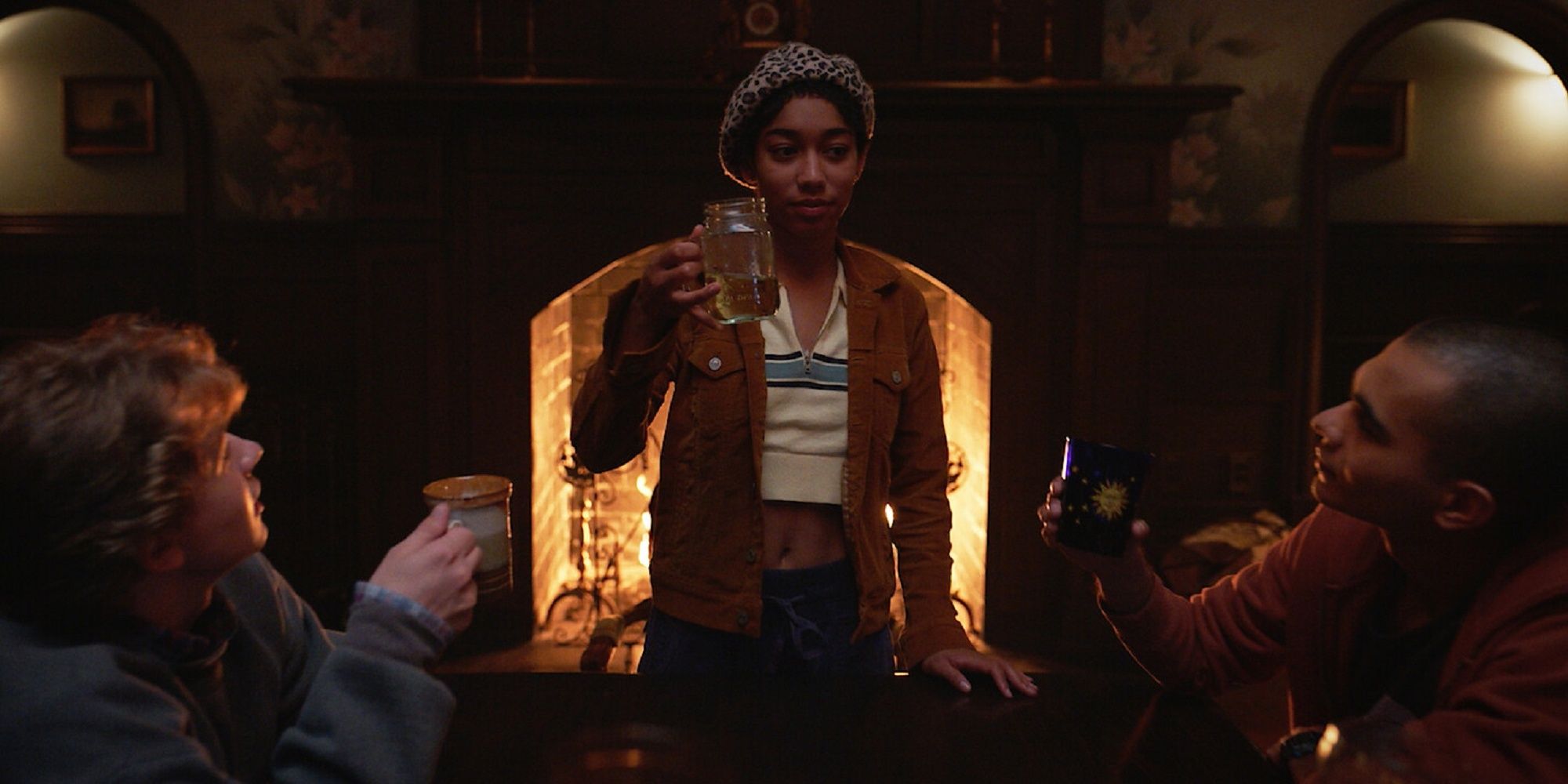 Iman Benson's character holding her glass up to cheers to her friends' drinks in 'The Midnight Club.'