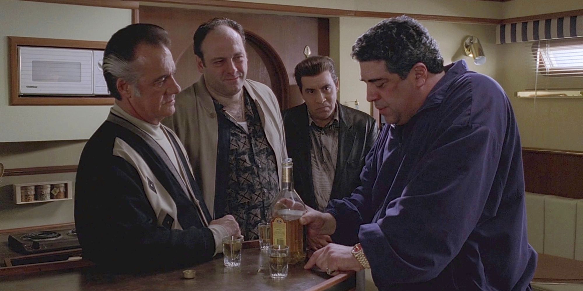 Tony and his associates gathered around a small bar table on a boat in The Sopranos