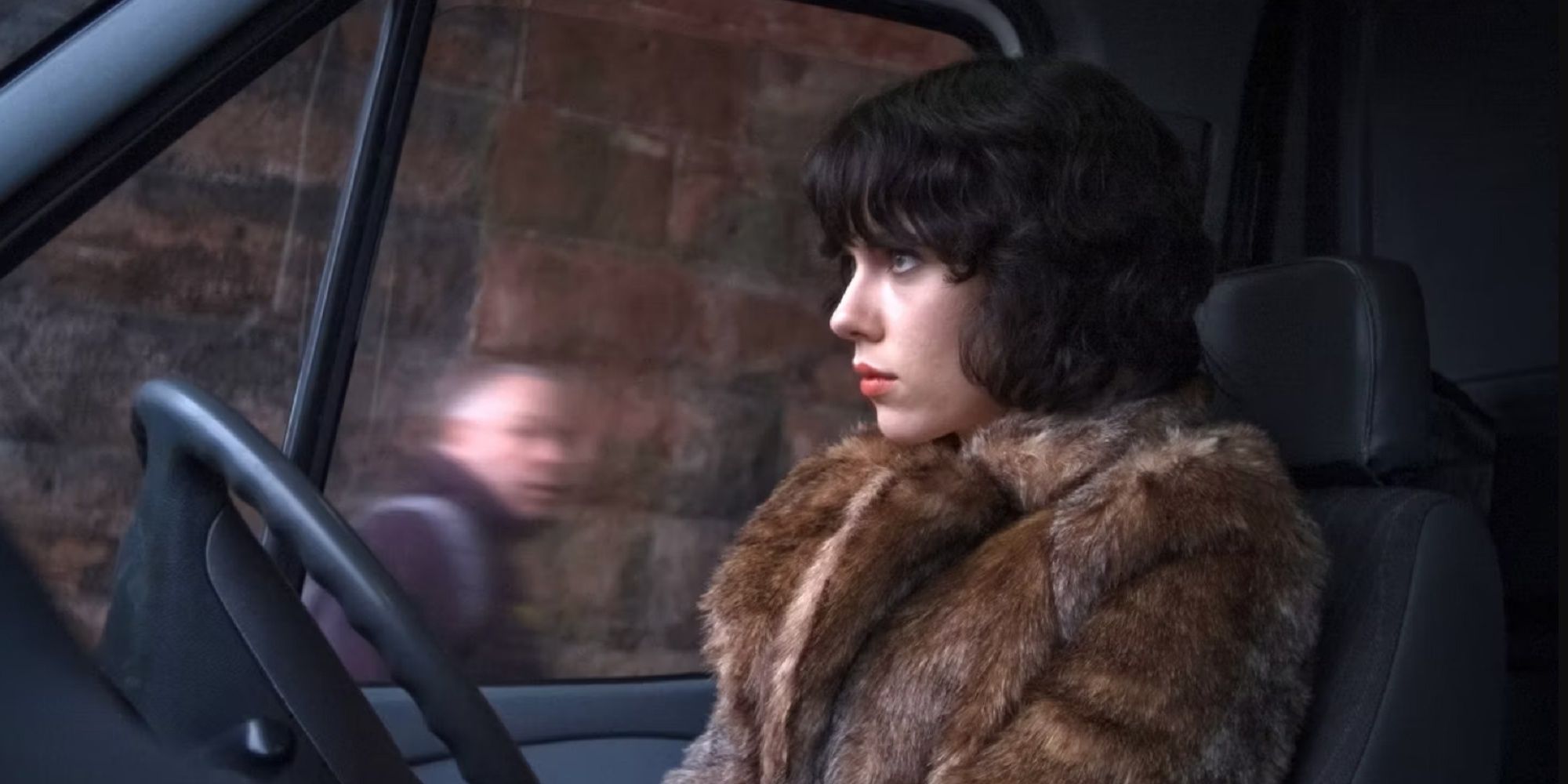 The Alien, played by Scarlett Johansson, drives by a man in the film Under the Skin.