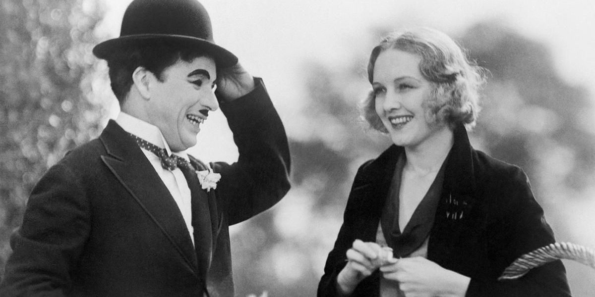 Charlie Chaplin and Virginia Cherrill as The Tramp and the Blind Girl smiling in City Lights.