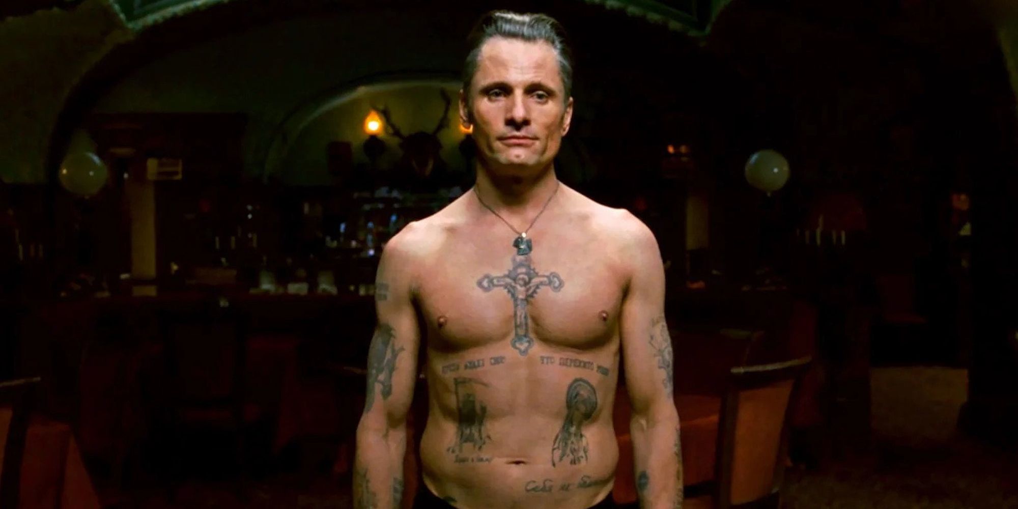 A shirtless man covered in tattoos looking intently in Eastern Promises