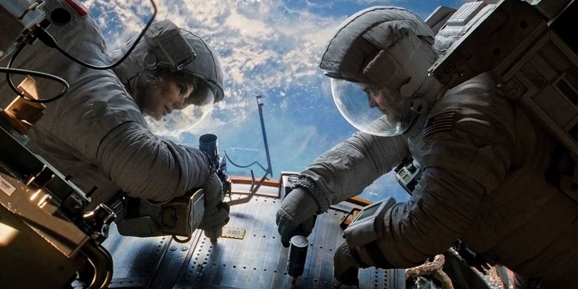 Two astronauts converse over their repairs 