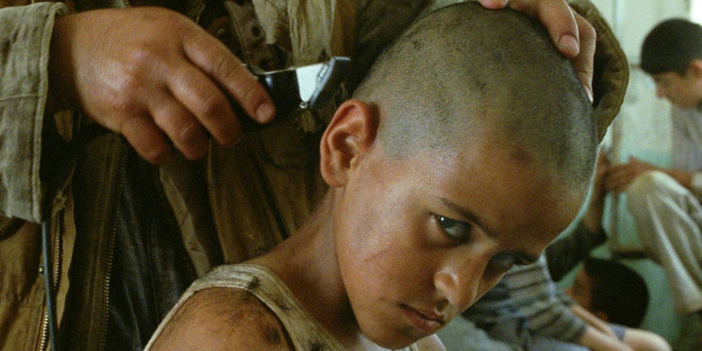 A bald child looking at the camera in Incendies with a saddened expression.