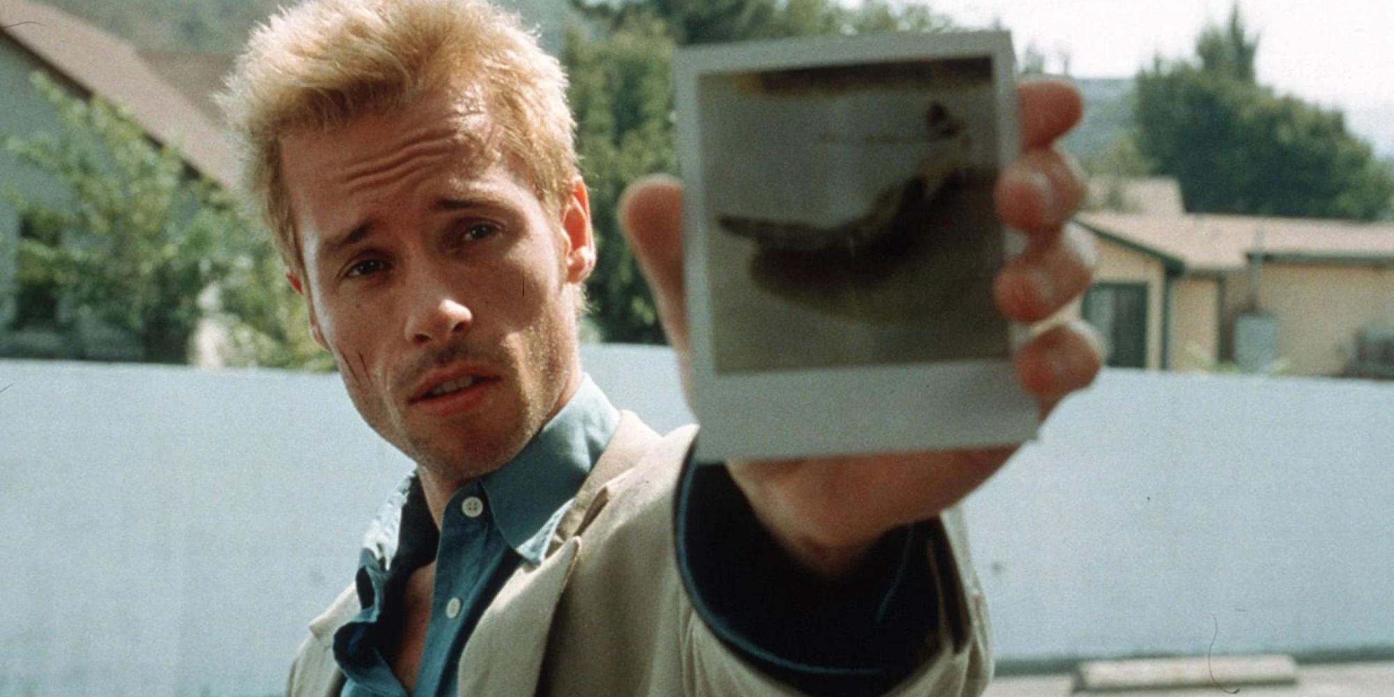 Guy Pearce sostiene una fotografía Polaroid en 