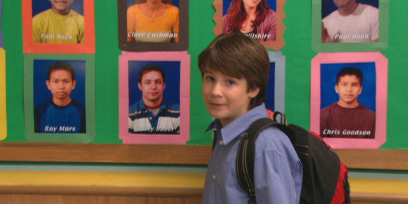 Ned in front of student photos