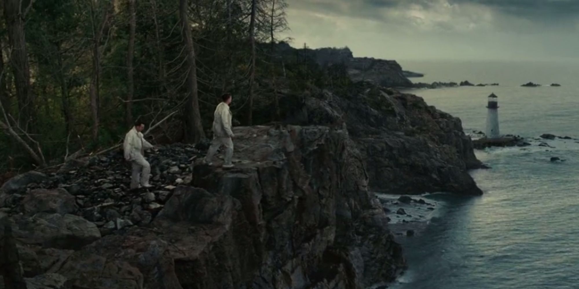 Teddy and Chuck peruse the coastal cliffs of Shutter Island, with a small lighthouse in the background
