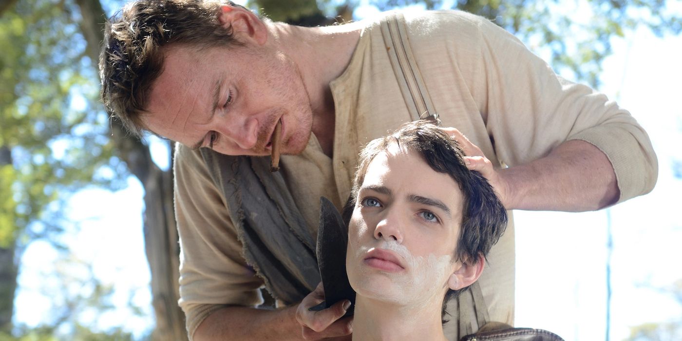 Silas shaving Jay with trees in the background in Slow West.