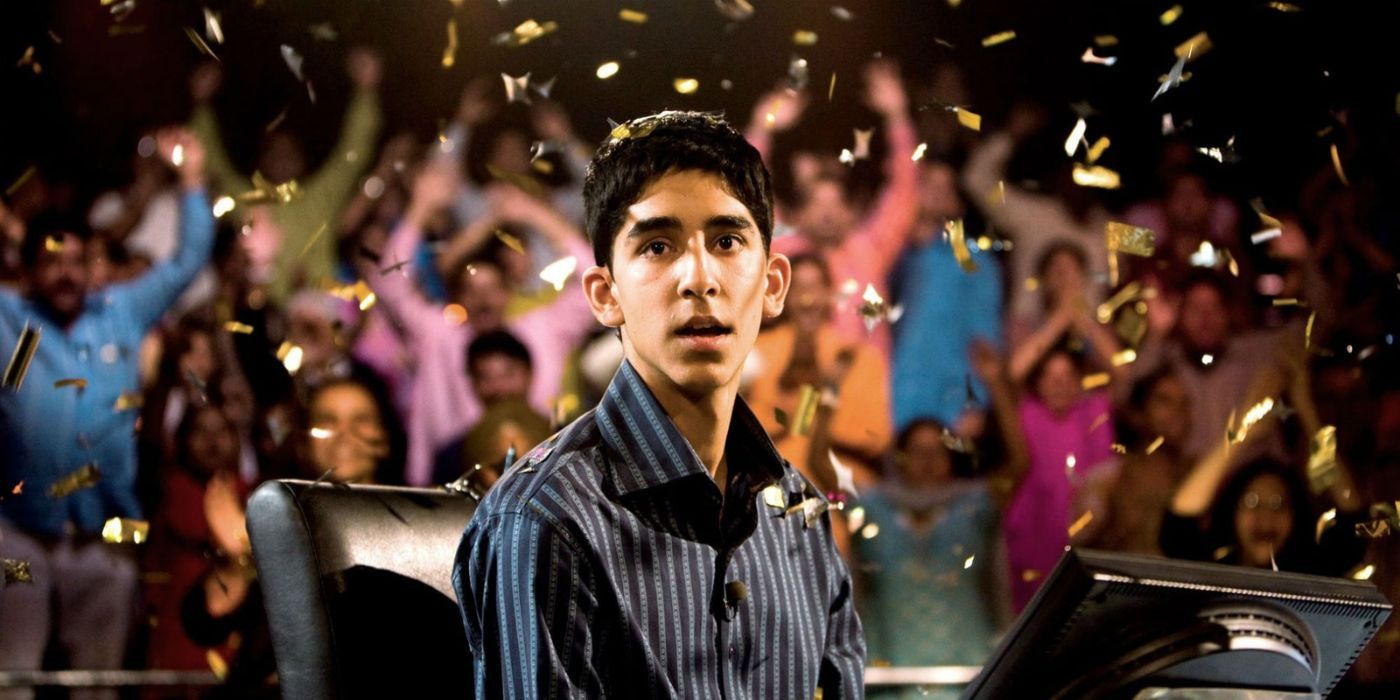 Jamal Malik looking shocked while confetti falls and a crowd cheers in Slumdog Millionaire (2008)