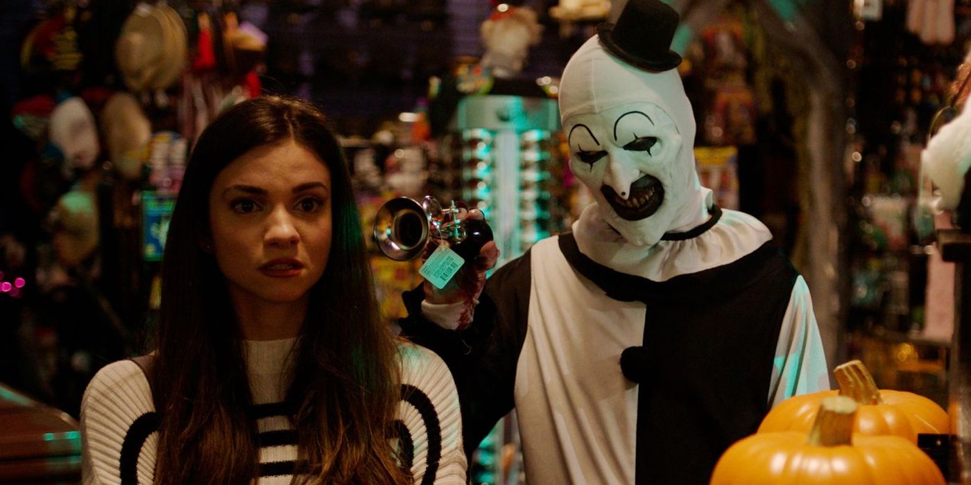 David Howard Thornton as Art the Clown tormenting Lauren LaVera as Sienna in a prop store in Terrifier 2