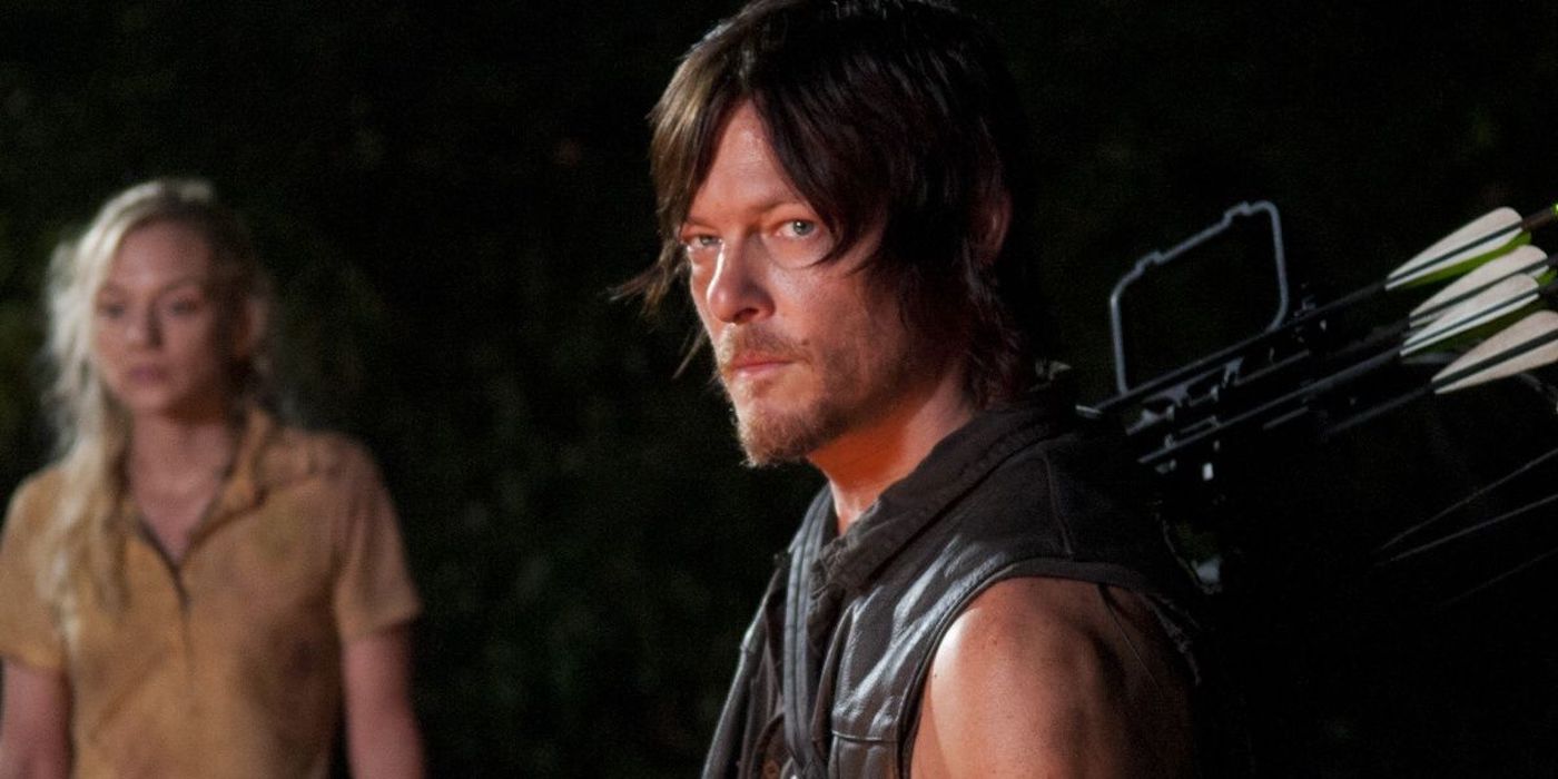 Norman Reedus as Daryl Dixon, looking serious while Emily Kinney as Beth stands behind him in The Walking Dead