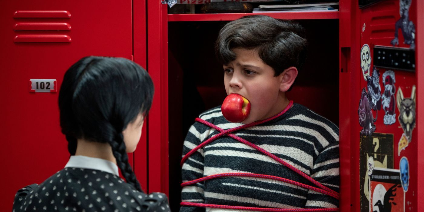 Pugsley, interpretado por Isaac Ordonez, está preso com uma maçã enfiada na boca em 'Wednesday' da Netflix.