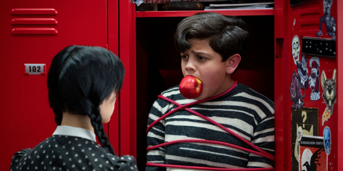 Pugsley, played by Isaac Ordonez, tied up in a locker with an apple shoved in his mouth in Netflix's 'Wednesday.'