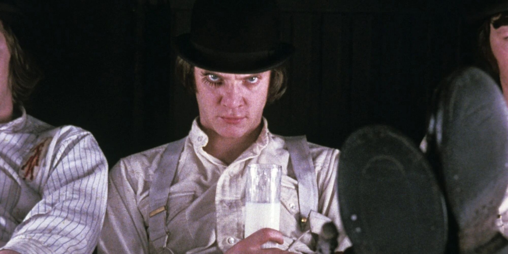 Alex in his iconic suspenders outfit looking into the camera in 'A Clockwork Orange.'