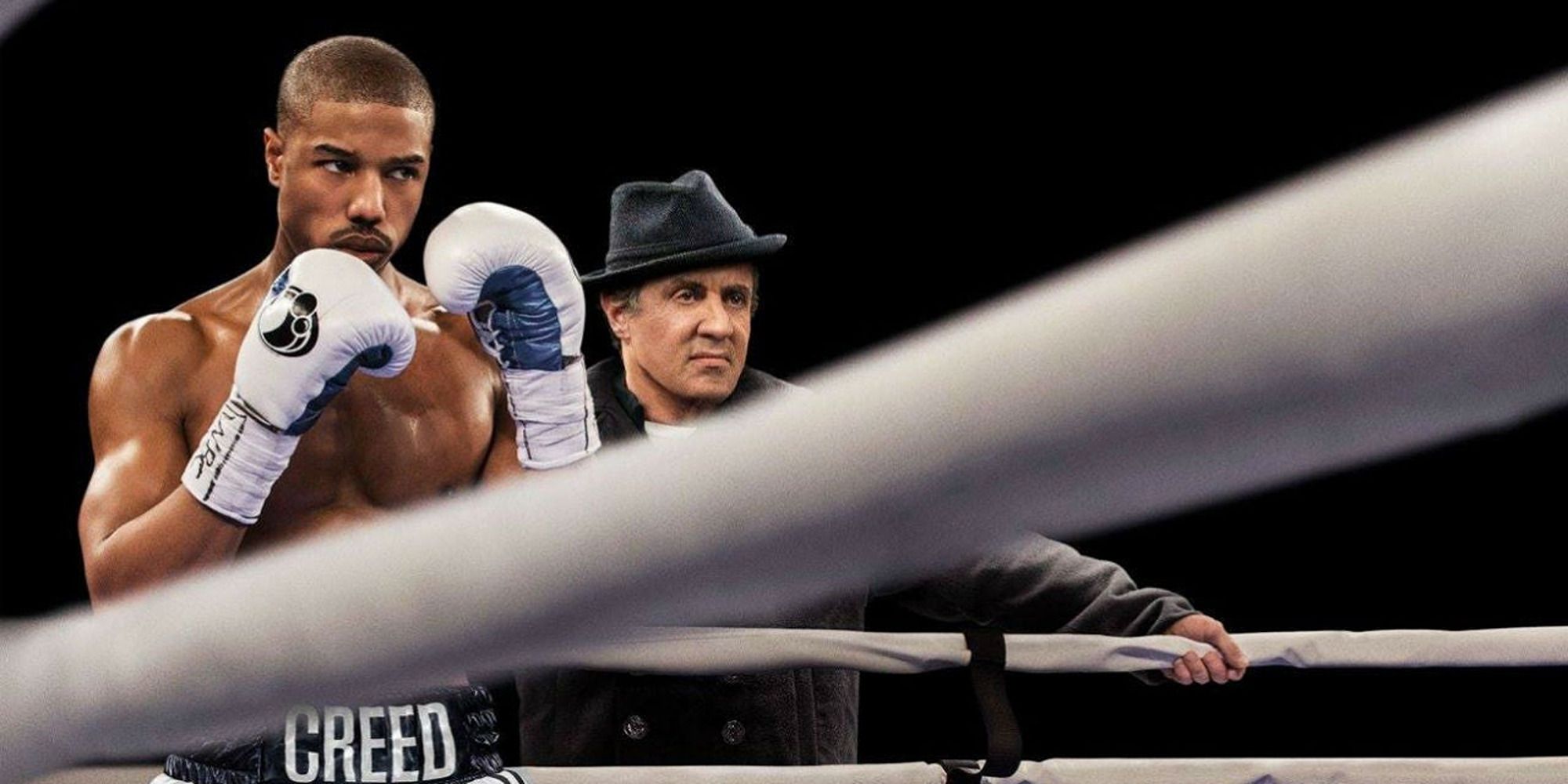 Michael B. Jordan sur le ring avec Sylvester Stallone derrière lui dans Creed.