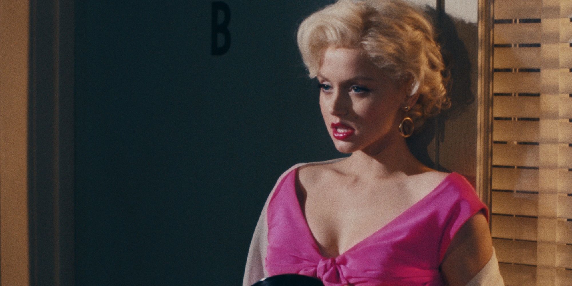 Marilyn Monroe em um vestido rosa e batom vermelho em 'Blonde'.